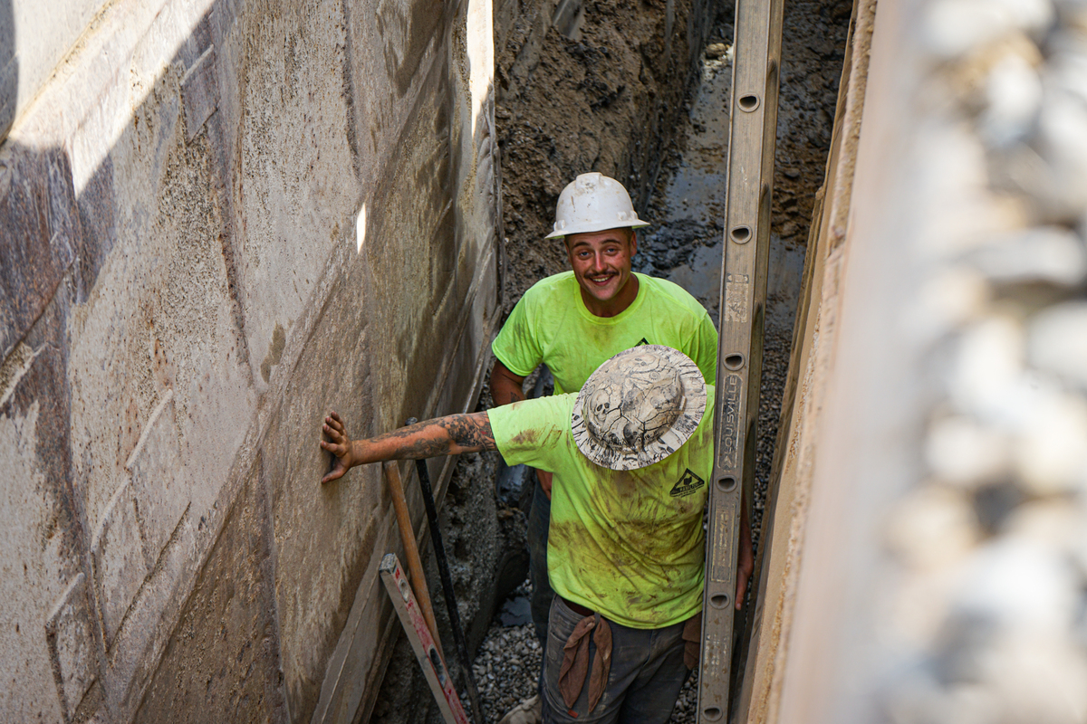 construction workers in a trench with hardhats